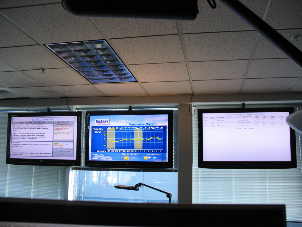 The three info screens hanging from the ceiling at T-Comm. Another set hangs along the wall to the left of this photo.