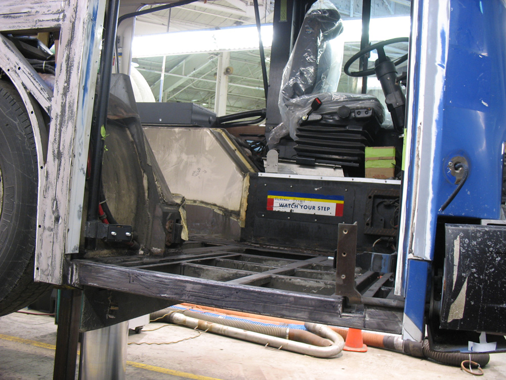 The front of the articulated bus being overhauled -- the floor panels have been completely stripped out.
