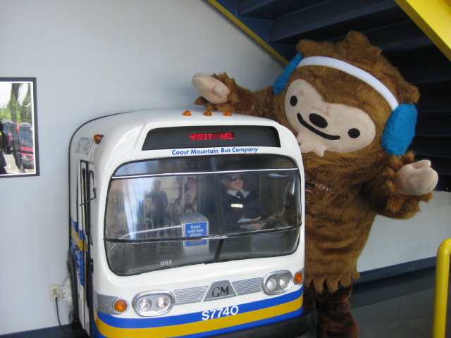 Quatchi plays with a miniature bus at Surrey Transit Centre.