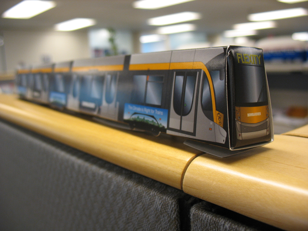 Oh yes - Bombardier gave out paper model streetcars! Here is mine atop my cubicle wall.