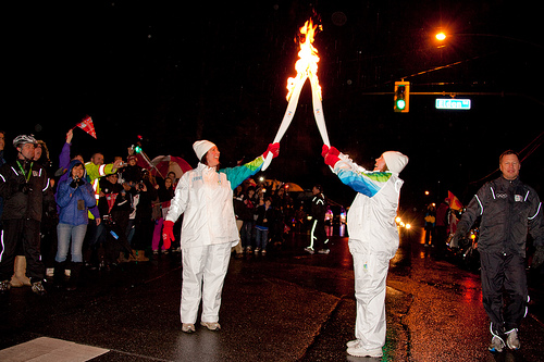 Chelsea from CMBC (right) receives the flame from the previous torchbearer on the North Shore.