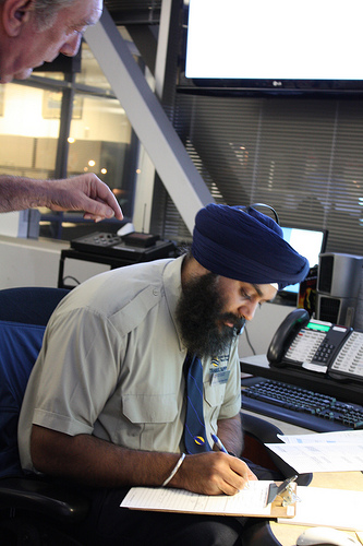 Still, in a room full of computers, there’s a little paper work to be completed. Here long time transit employee, Barry, assists Kuldip, trainee (whose spelling and penmanship I checked).