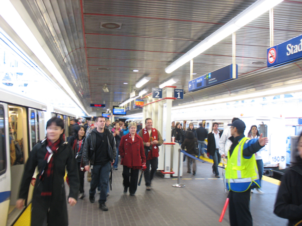 Crowds on the platform being directed to B.C. Place through the Expo Blvd exit. Staff and signage on the platform were clearly pointing out where people should go.