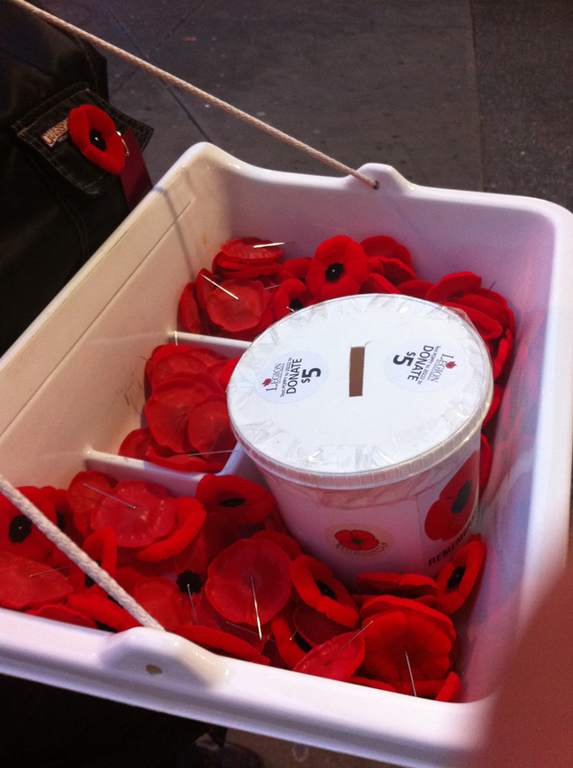 A tray of poppies being sold outside of a SkyTrain station.