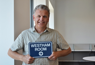 Bob holding a sign to a TransLink meeting room with the same name as the bridge.