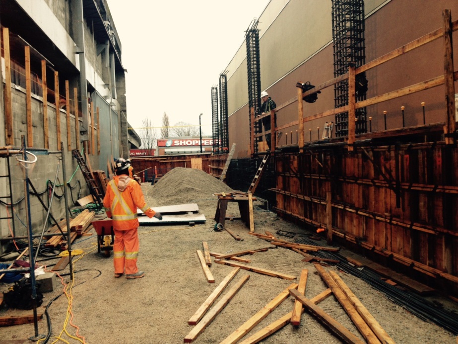 View looking north between Broadway Station and Safeway showing formwork and rebar for new east wall and columns