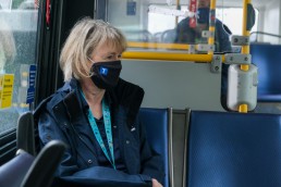 Person wearing a mask riding the bus