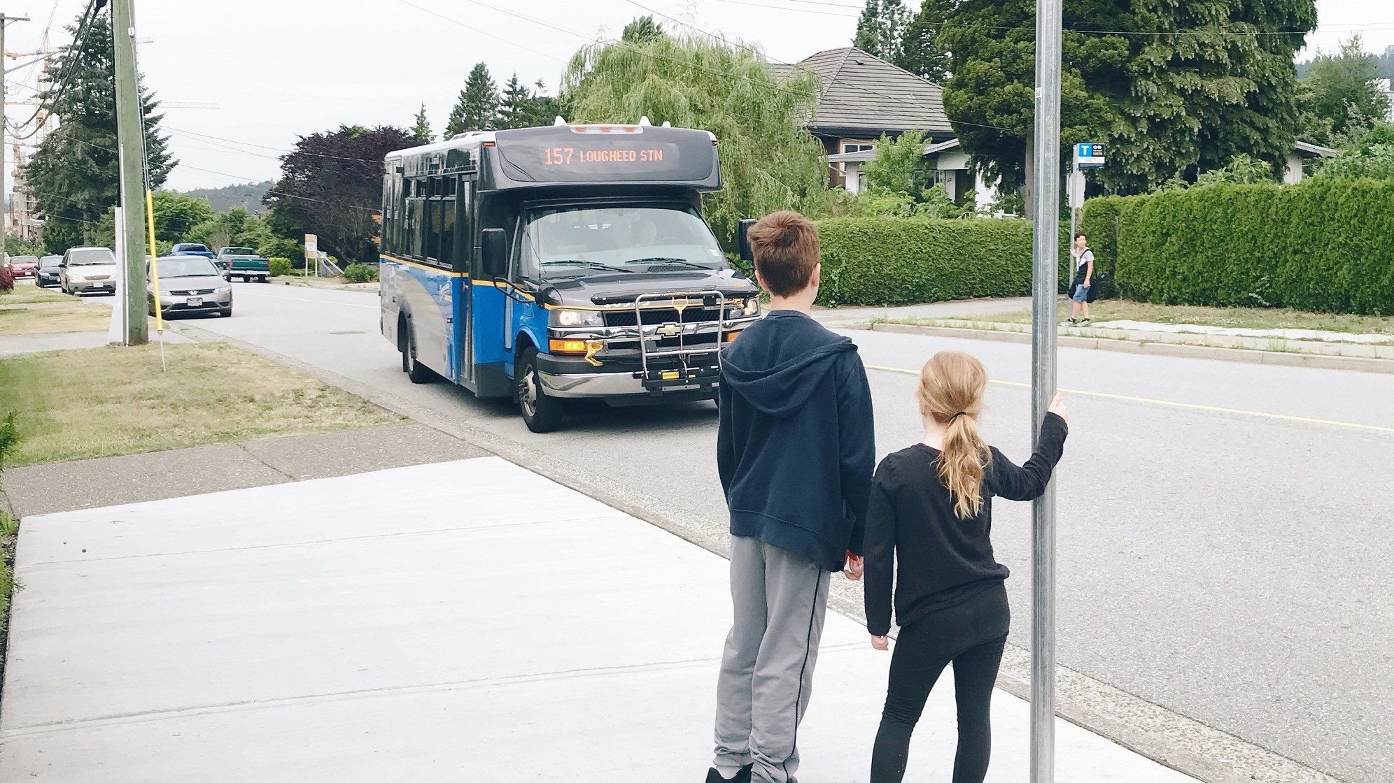 A pair of kids wait for the 157 Lougheed Station bus