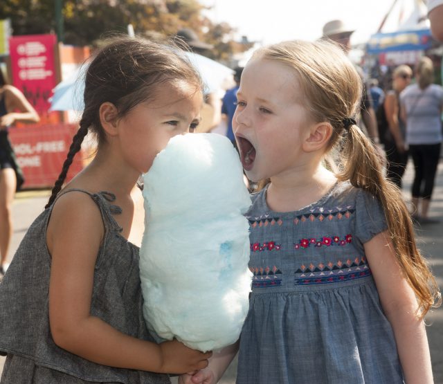 A couple of kids enjoying cotton candy at the PNE Fair