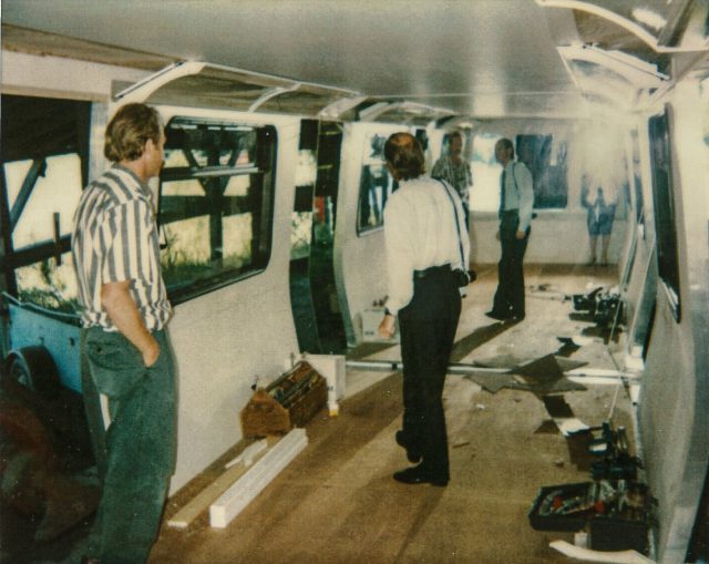 The inside of the Mark II mockup. Two men can be seen with their reflections on the mirror in the background.