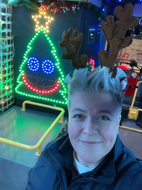 Bus operator Erika Jensen poses for a photo onboard the Reindeer Bus with the Christmas tree lights