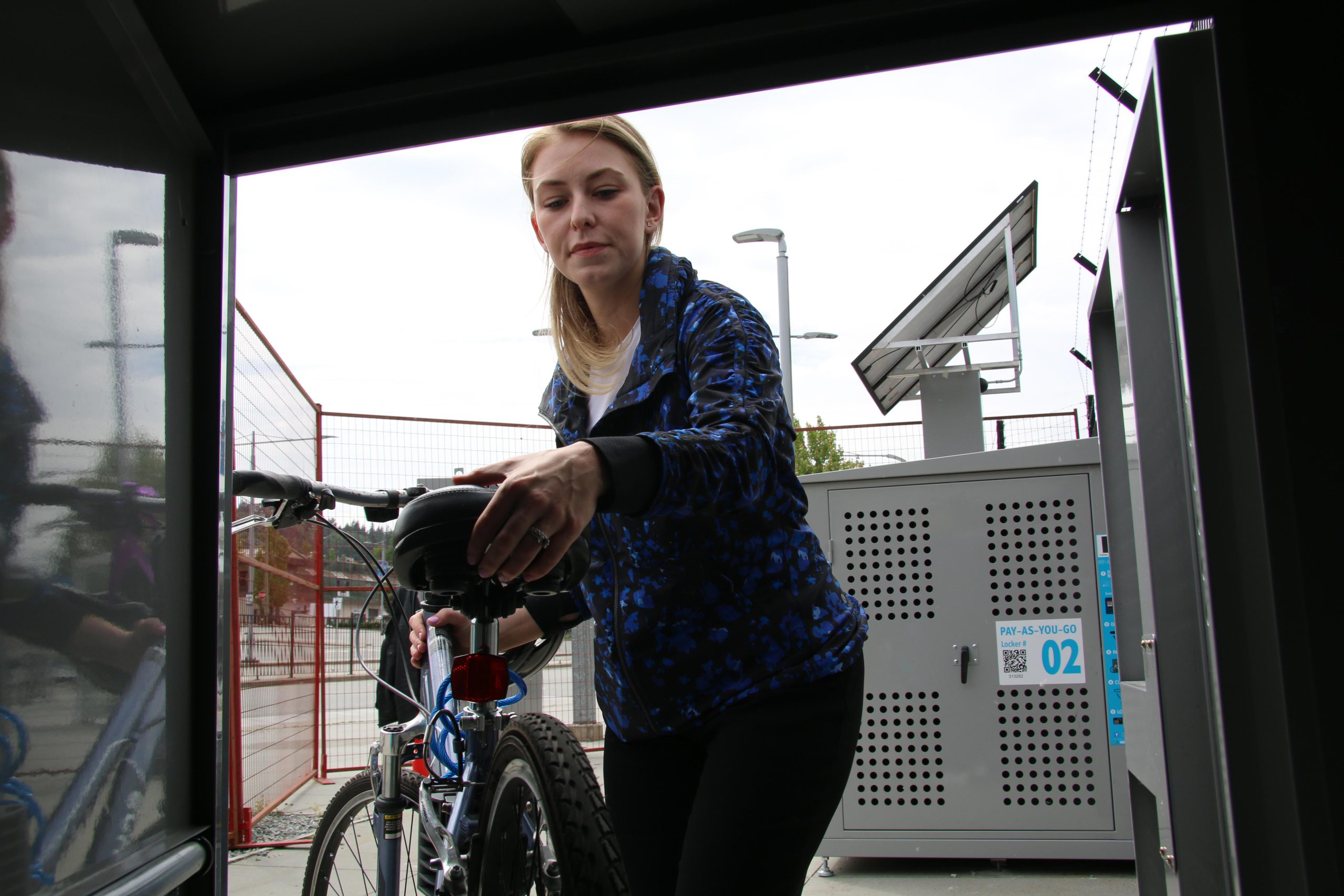 TransLink spokesperson Tina Lovgreen loads a bicycle into the new on-demand bike lockers