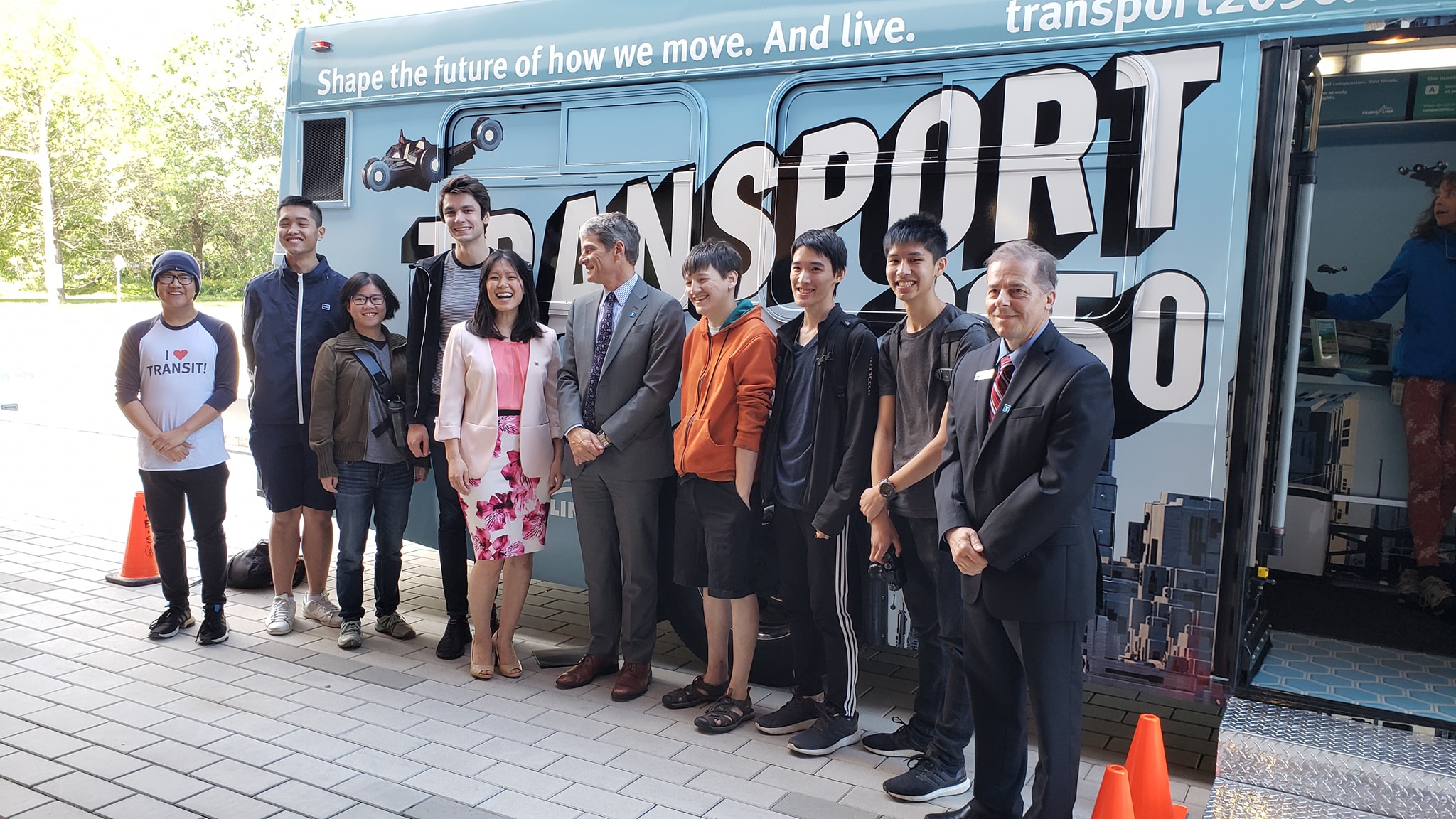 ALT: ELMTOT members with Bowinn Ma, ____ and ____ poses behind the Transport 2050 shuttle.