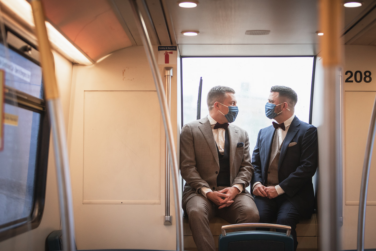 Two grooms sit at the front of the SkyTrain gazing into each others eyes