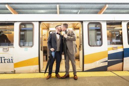 Grooms kiss on the SkyTrain platform in front of SkyTrain