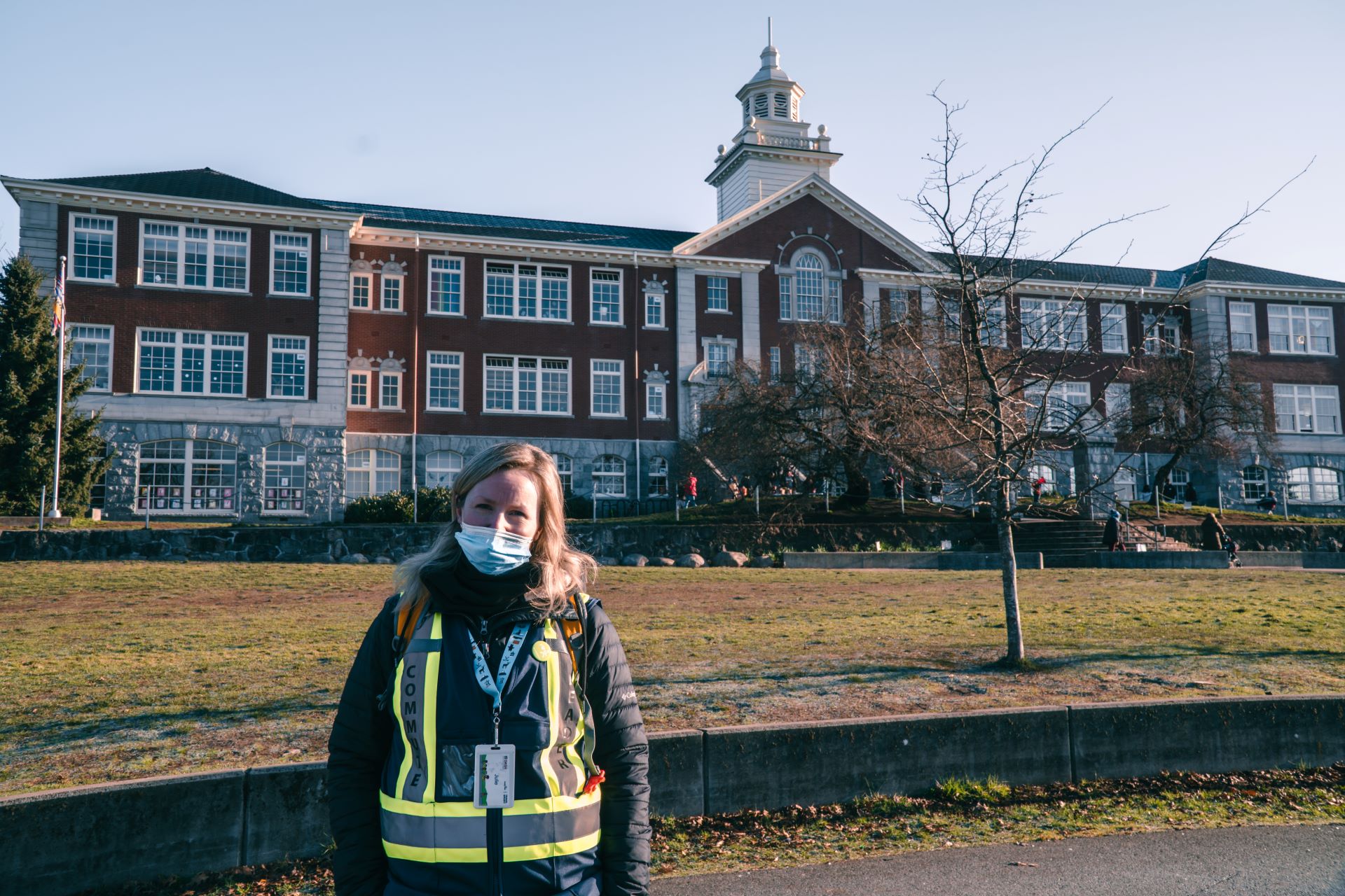 Julie Falk, a Walking School Bus leader stands in front of Queen Mary Elementary School