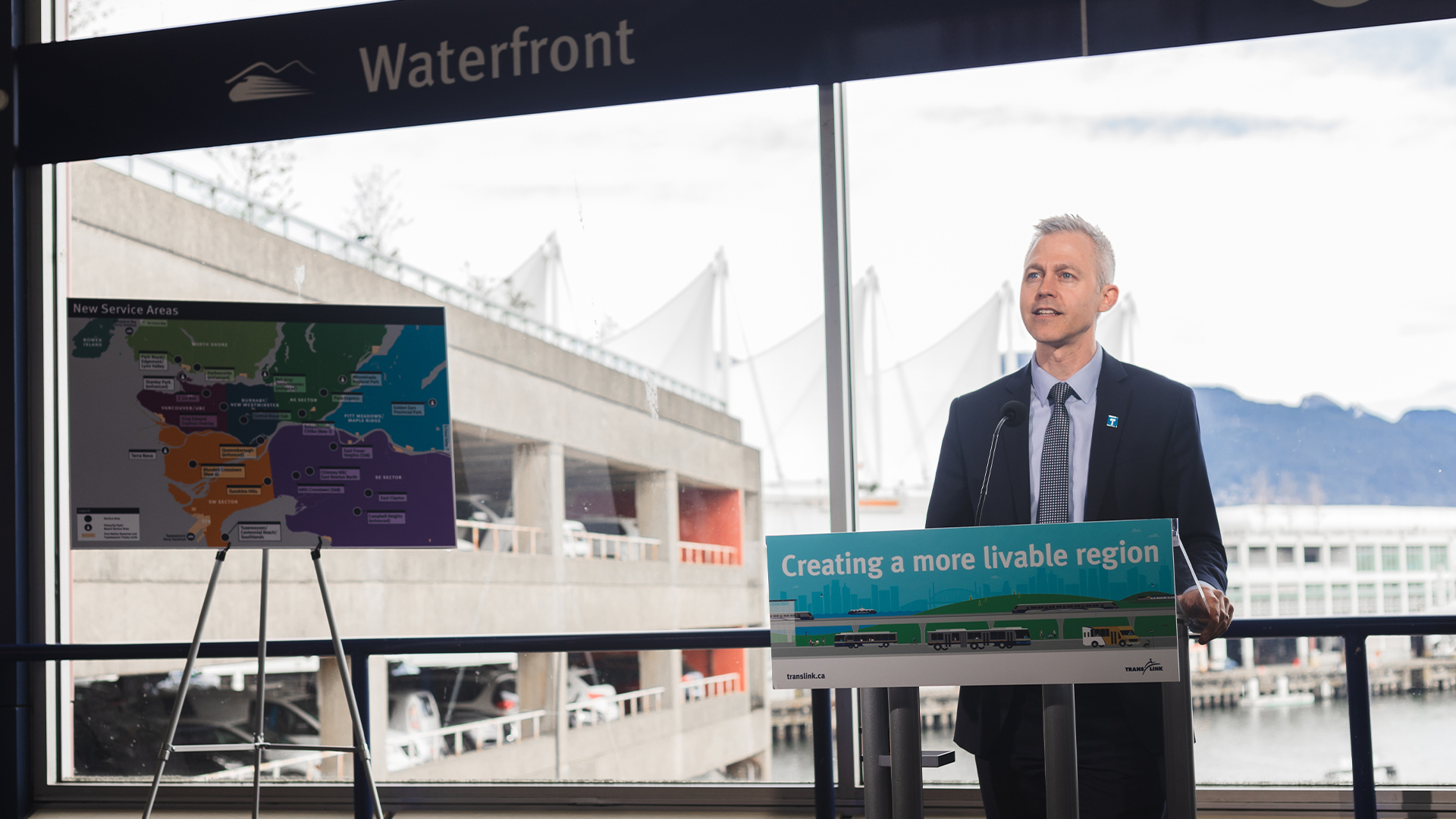 Kevin Quinn speaking on a podium during the 10-Year Priorities media event at Waterfront Station