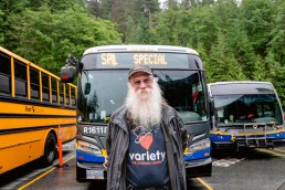 Keith Story standing behind a bus he drove to bring kids to Variety Charity's Grouse Mountain picnic