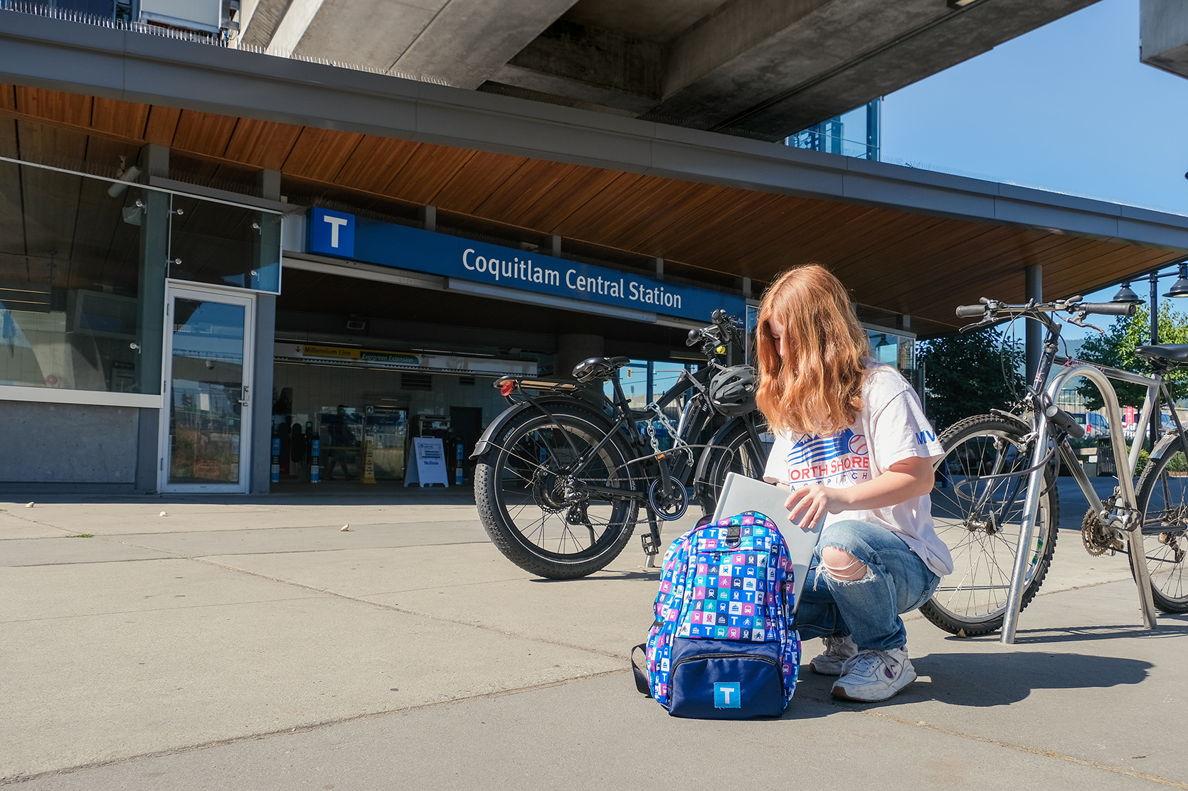 Student with TransLink backpack in front of Coquitlam Central Station