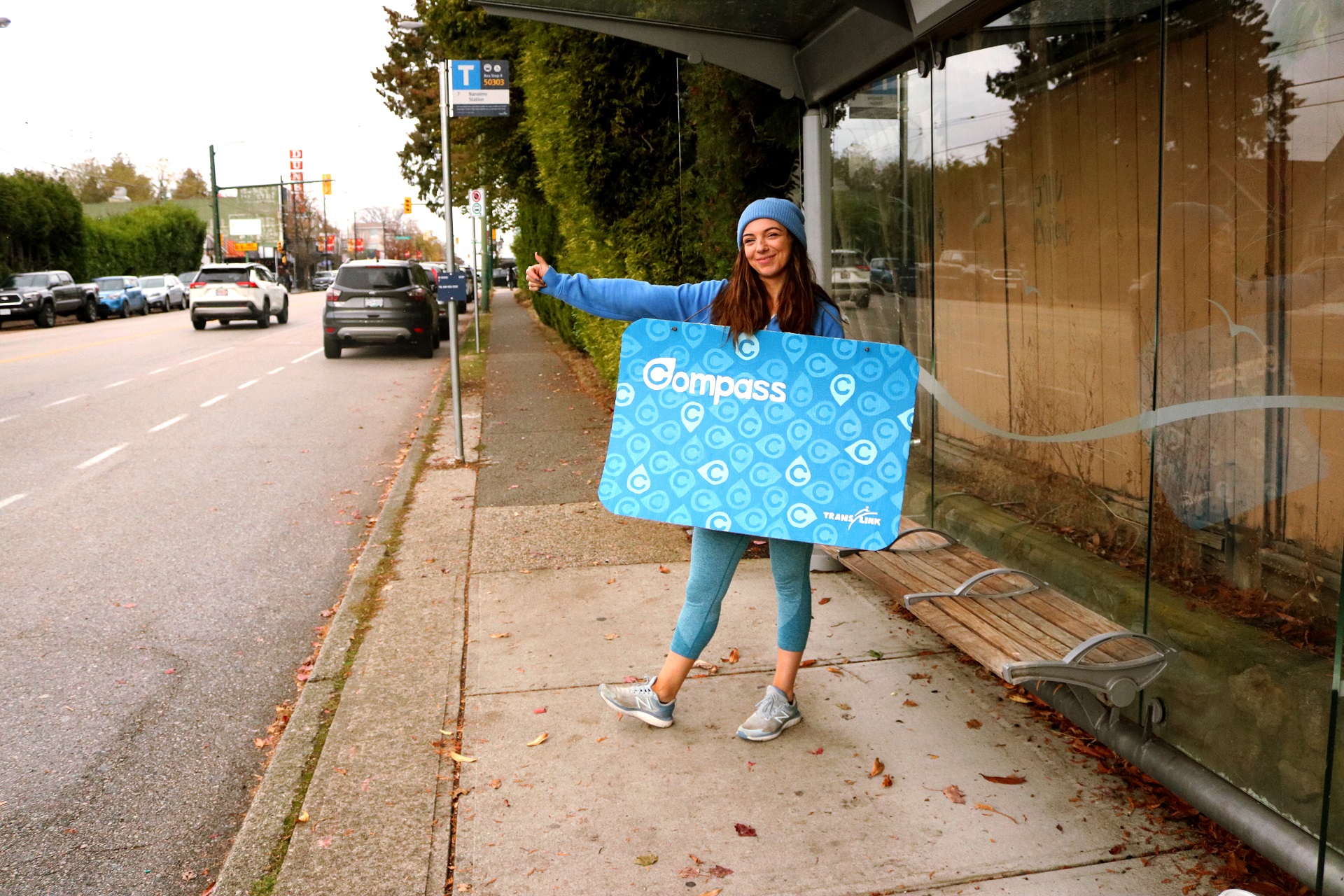 Photo of a woman at a bus stop dressed in a Compass Card Costume