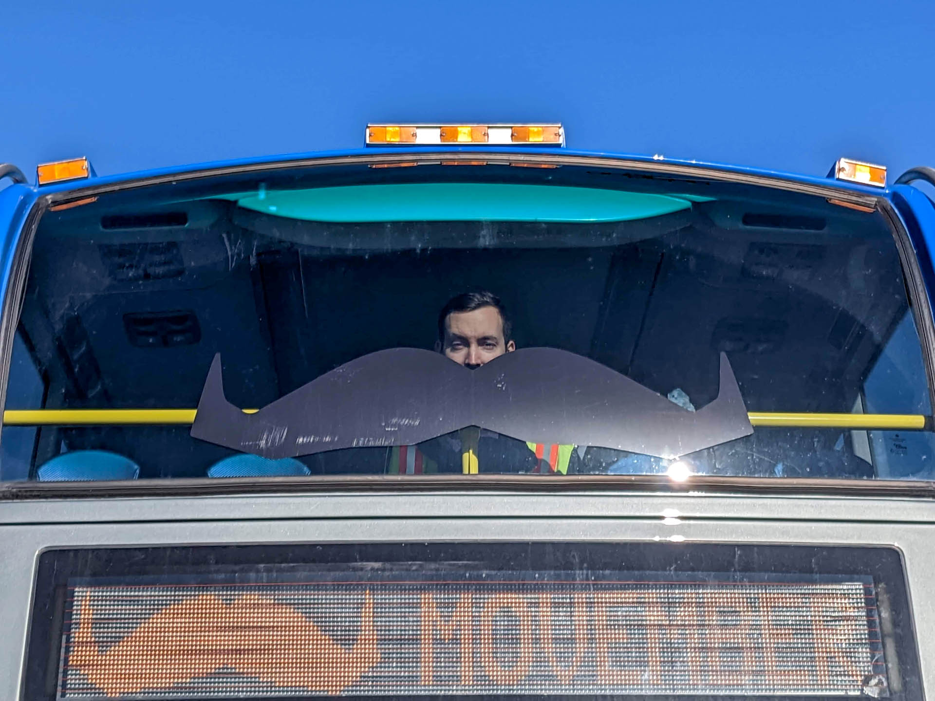 Photo of man sitting in the top deck of the Movember bus-stash double-decker bus