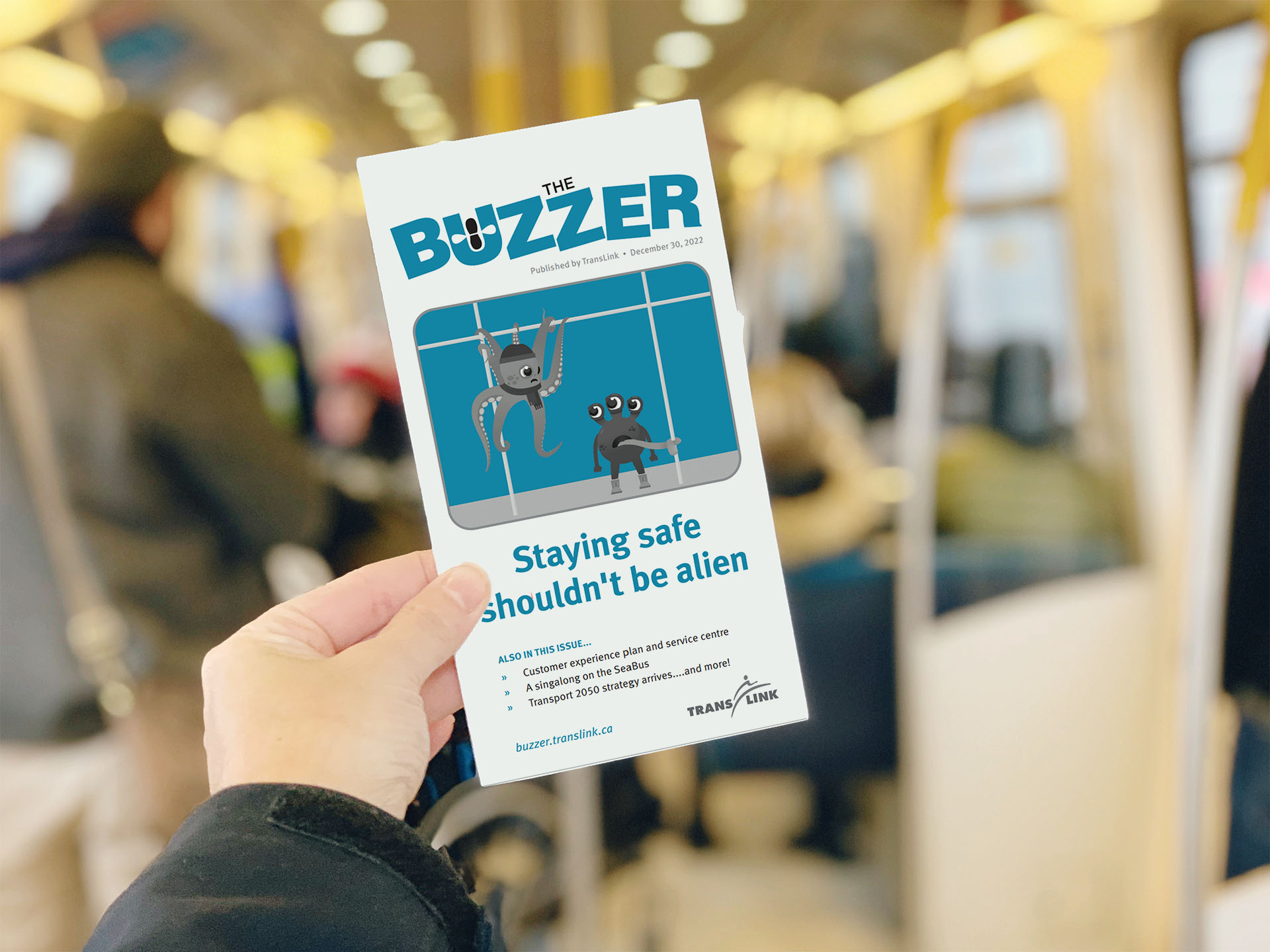 Rendering of a person holding an issue of The Buzzer on the SkyTrain
