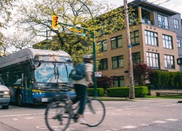 Cyclist passes a bus on the Arbutus Greenway
