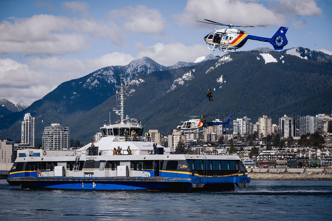 Helicopters fly above the SeaBus during a security exercise.