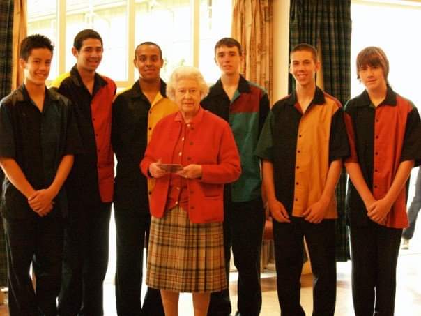 A group of six teenage boys pose for a photo with Her Majesty Queen Elizabeth II