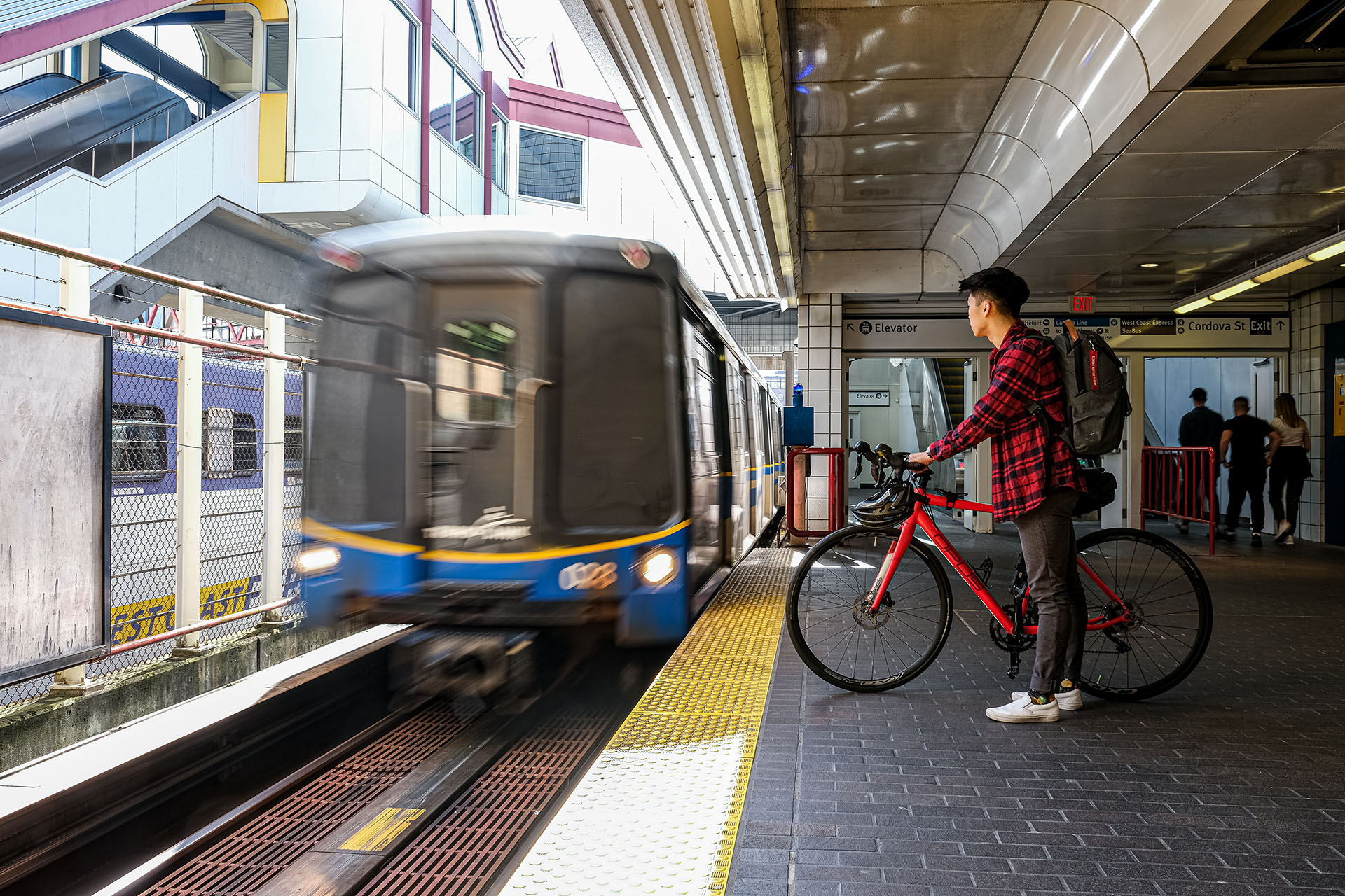 A person on a bike, waiting for the SkyTrain