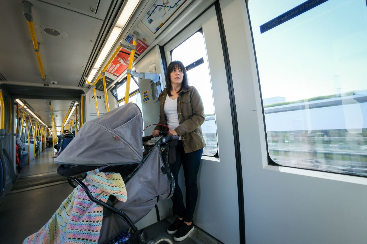 Person riding the SkyTrain with a stroller