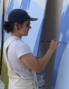 Natalie Warkentin painting a mural