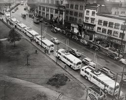 View of eight trolley buses lined up on Pender for the first trolley service. Free rides were offered. 1948