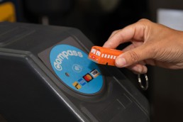 A person taps a Compass Mini-Trolley at a fare gate