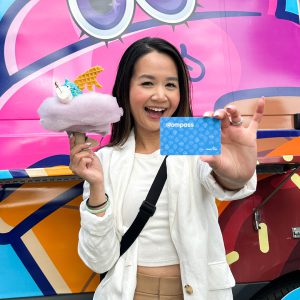 Girl holding a Compass Card and ice cream with cotton candy n top.