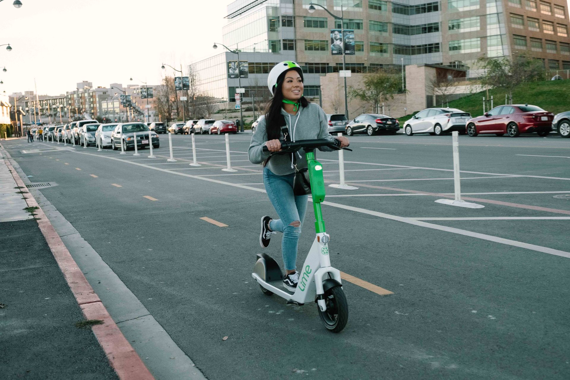 Person riding a Lime scooter in a shared pathway