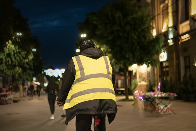 Person riding a bike at night, with a high-visibility reflective vest