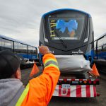 Loading the Mark V SkyTrain in Kingston, Ontario. Train wears a blue ribbon on its windshield.