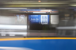 Train passes by and a BMO Vancouver Marathon ad is visible in the background.