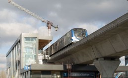 A SkyTrain travels past the under construction Capstan Station