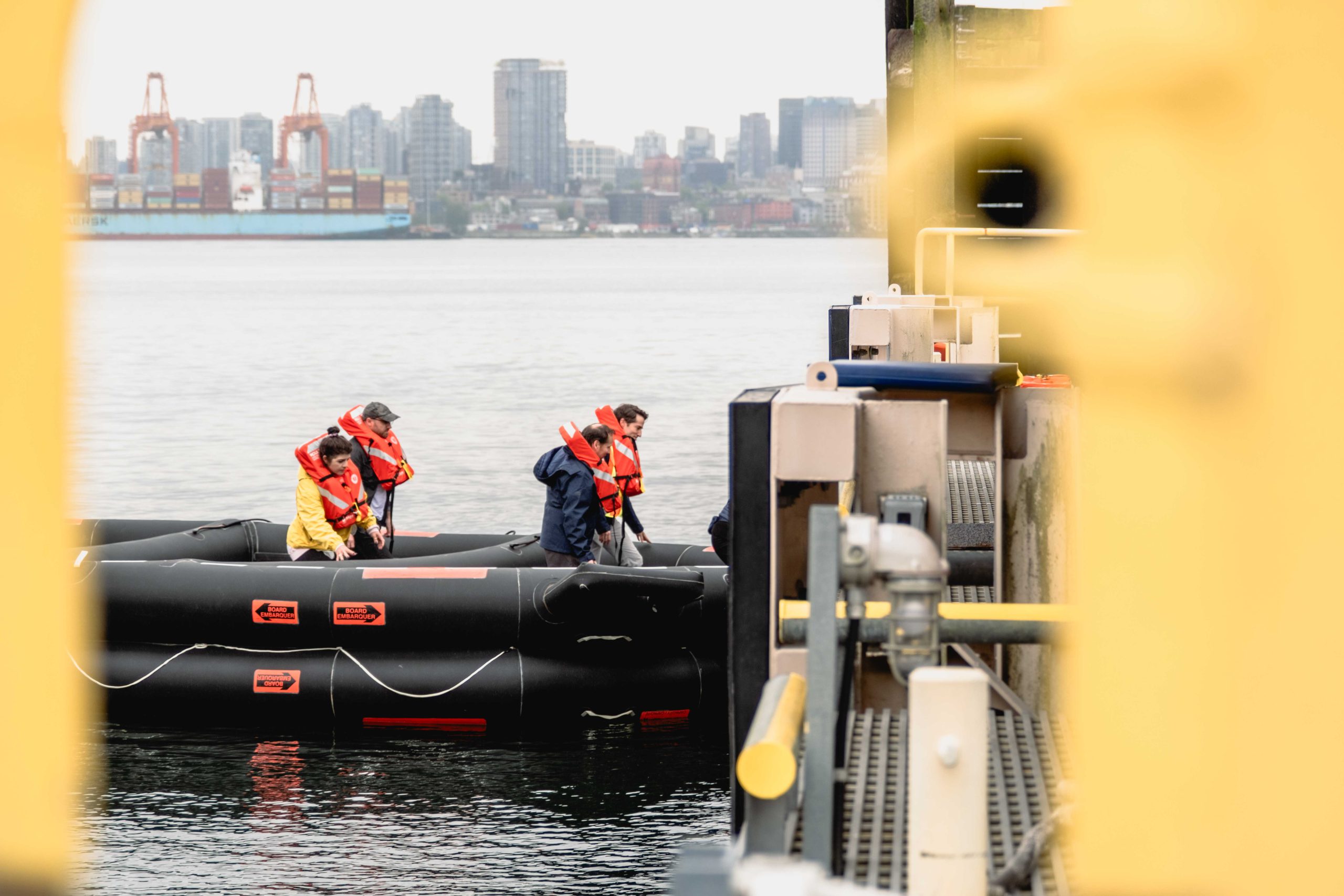 SeaBus passengers arrive safely to shore, stepping out of the life raft.