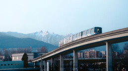 SkyTrain travelling on the Expo Line with snowy mountains in the background