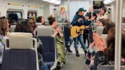 A person with guitar singing aboard the West Coast Express