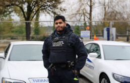 Transit Security Officer Adam Shah stands in front of cruisers