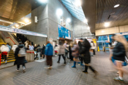 People passing through the concourse of Stadium–Chinatown Station en route to The Eras Tour