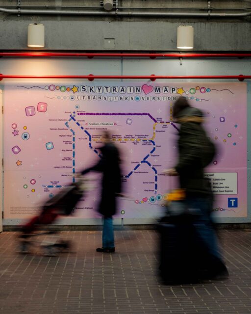 A family walks by TransLink's SkyTrain map at Stadium–Chinatown after it receives friendship-bracelet makeover