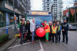 TransLink CEO Kevin Quinn and staff volunteers load the 100,000th toys for tots donation onto the Reindeer Bus