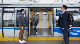 passengers use proper transit etiquette and wait to board a SkyTrain as the doors open to let another customer out