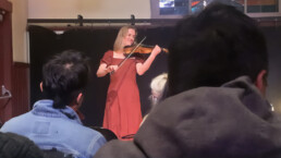A screen capture of the video showing Maya Eliza playing the violin