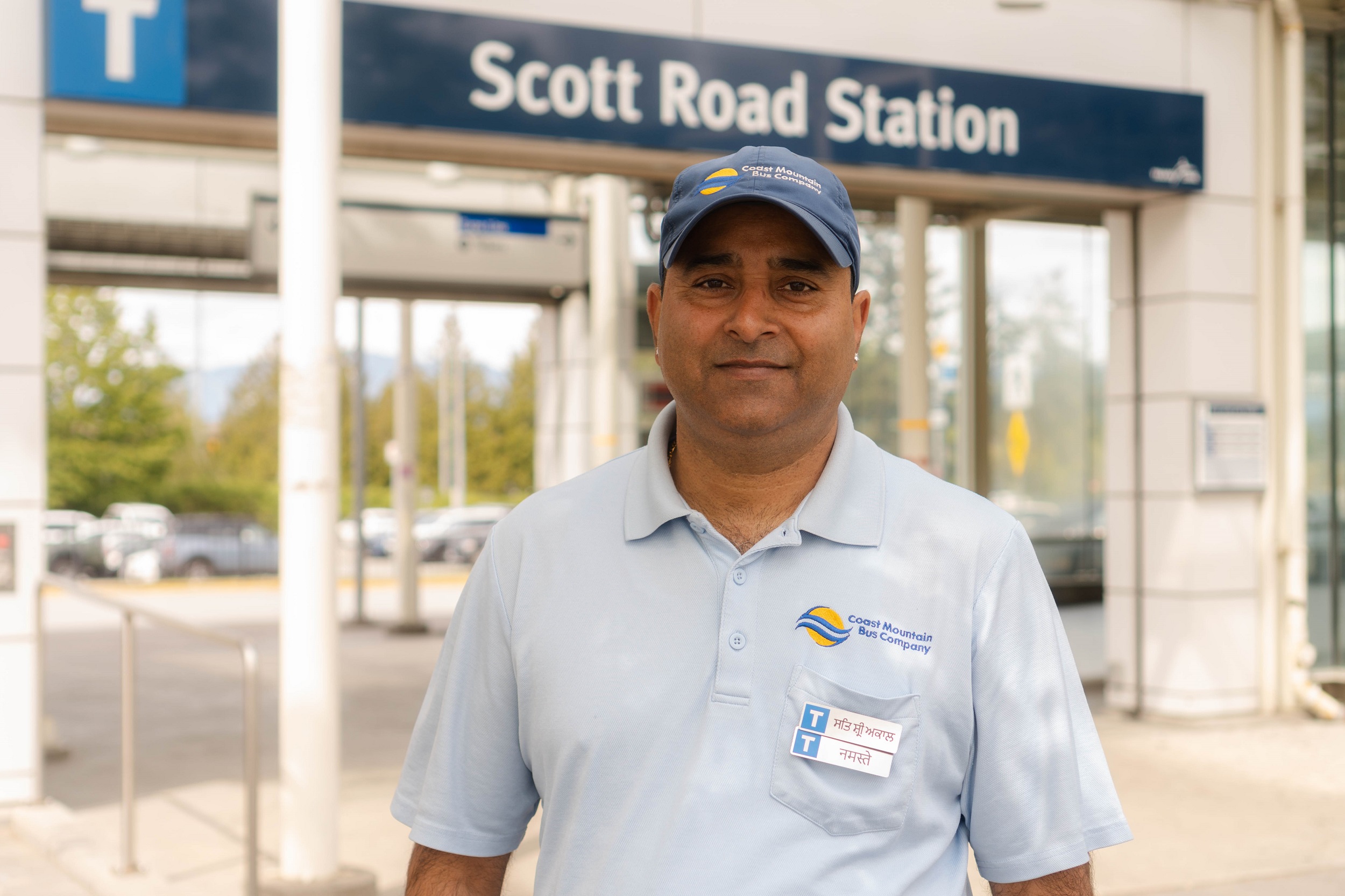 Bus operator Anil Pathak wears a Language Pin outside Scott Road Station